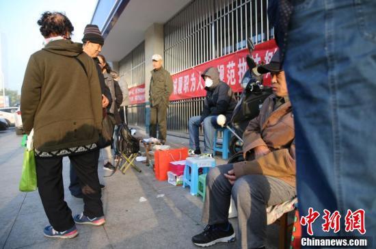 来京人员排队办理北京居住证 用板凳、砖头占