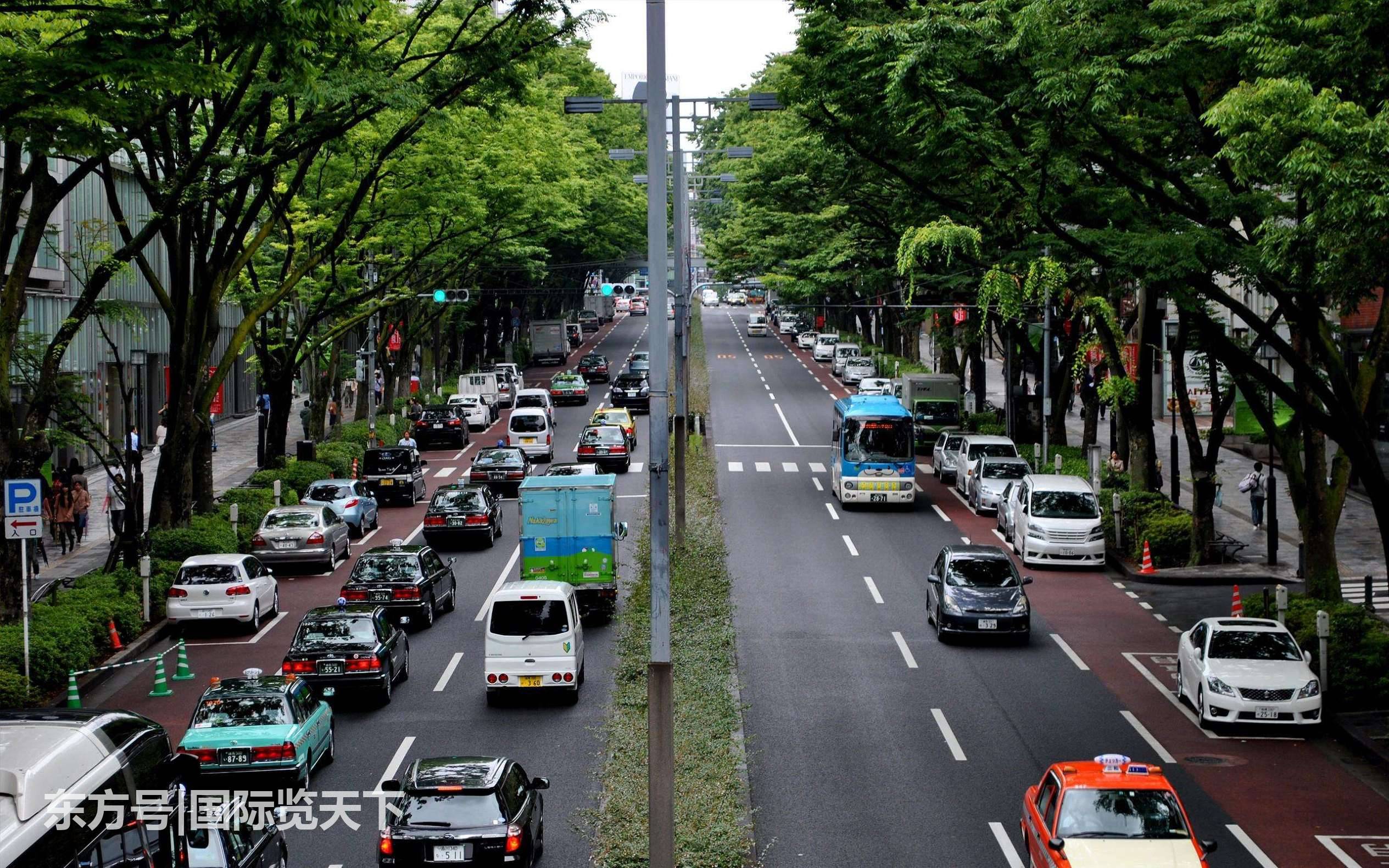 图为日本城市的街道,多辆汽车在有秩序地向前推行,马路上同样看不到